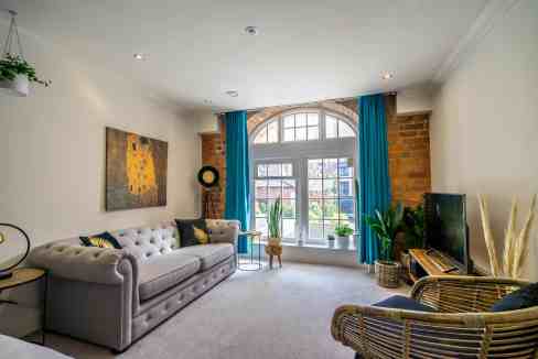 Bright and inviting living space with large window, stylish furniture, and vibrant decor. Perfect fo.