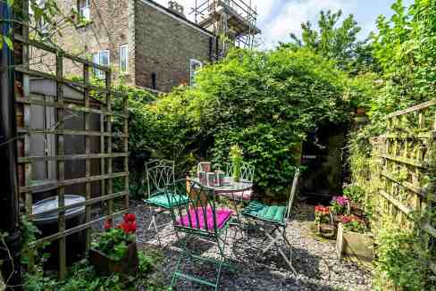 Charming garden scene with outdoor seating and lush greenery.