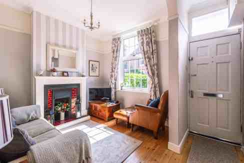 Bright living room with fireplace, large window, and comfortable seating.