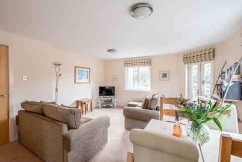 Bright living room in Crambeck Court Apartments with comfortable sofas and natural light.