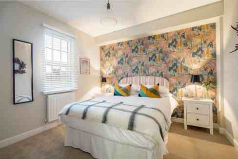 Bright bedroom with floral accent wall and modern decor.