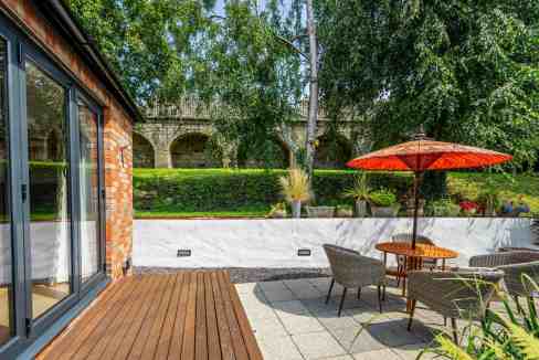 Outdoor patio at Hunt Court Apartments with seating and umbrella.