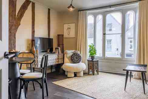 Bright living room with large windows, modern furniture, and decorative accents in Micklegate Apartm.
