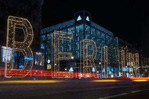 Bright LED "BELIEVE" sign on a modern building at night.