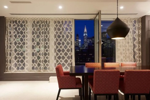 City skyline view from the One Park Avenue Apartments living room at night.