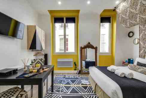 Stylish bedroom in Sentier Apartments with vibrant yellow accents and contemporary decor.