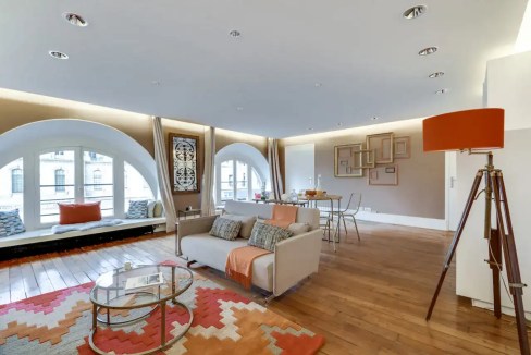 Elegant living room with large arched windows and modern decor.