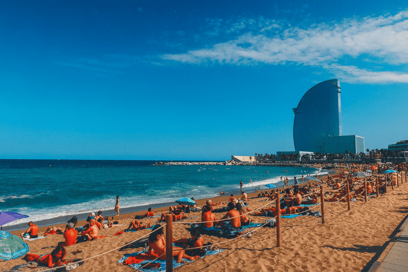 Beach in Barcelona with the W Hotel, sunny weather, and visitors enjoying the seaside.
