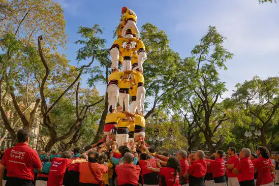 Human tower formation during a traditional Catalan festival in Barcelona park.