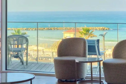 Scenic view of the sea from Bugrashov Beach Apartments balcony with seating area.