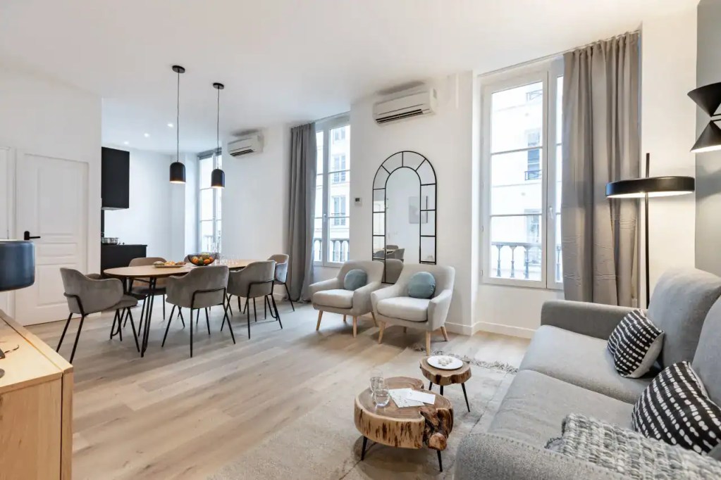 Spacious living room in Quatre-Septembre Apartments with modern decor and natural light.