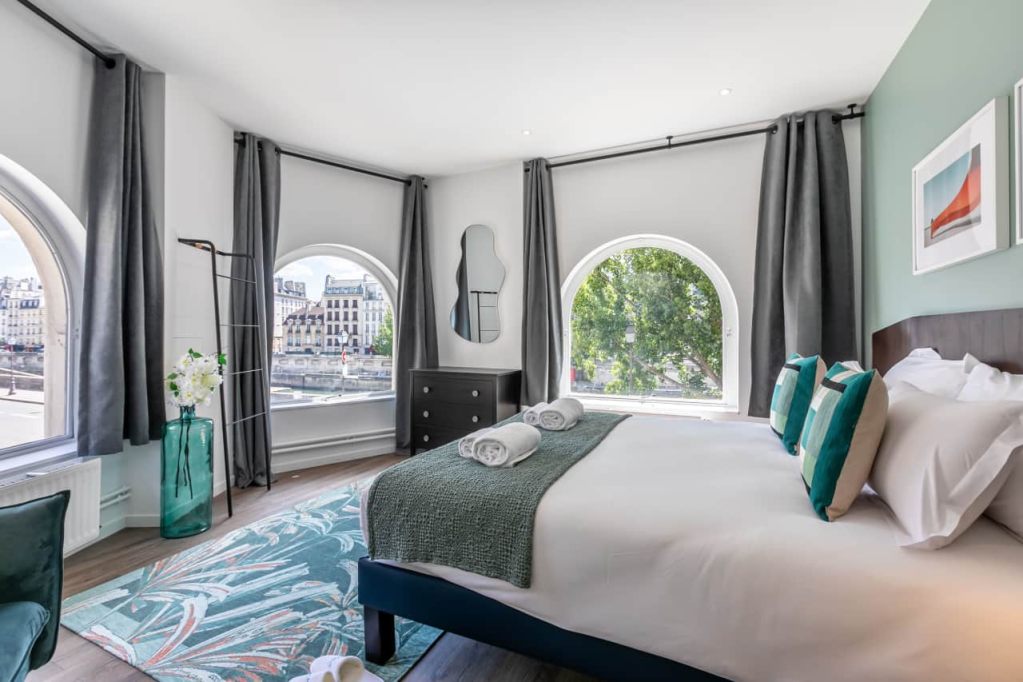 Elegant apartment with large arched windows and modern decor.