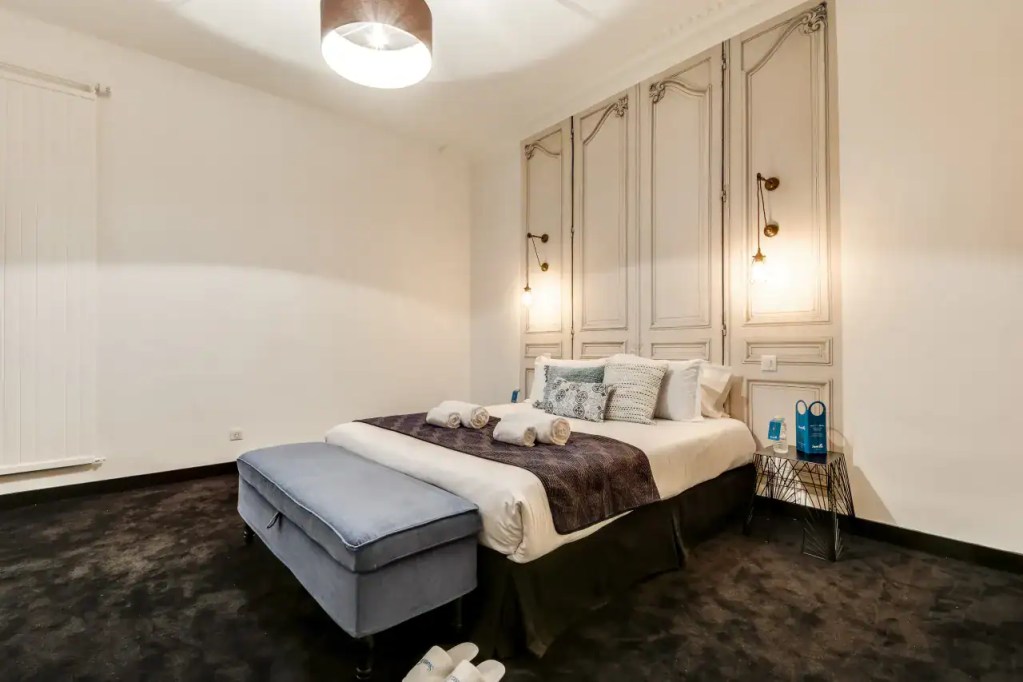 Luxurious bedroom in Paris Opera House Apartments with classic decor and cozy ambiance.