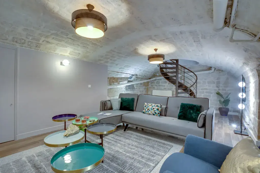 Modern Trévise Apartments living room with stylish furniture and unique vaulted ceiling.