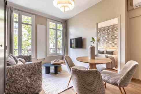 Bright living space with large windows, contemporary furniture, and cozy ambiance.