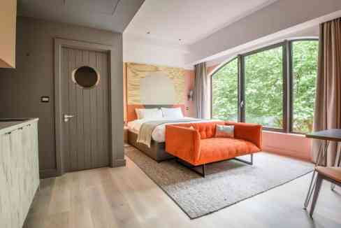 Modern hotel room with large window and stylish decor.