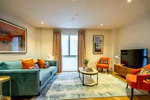 Modern living room at York Station Apartments with colorful furniture and natural light.