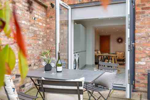 Charming outdoor patio of Fulford Main Street House with seating and greenery.