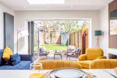 Bright living room with large glass doors opening to outdoor patio.