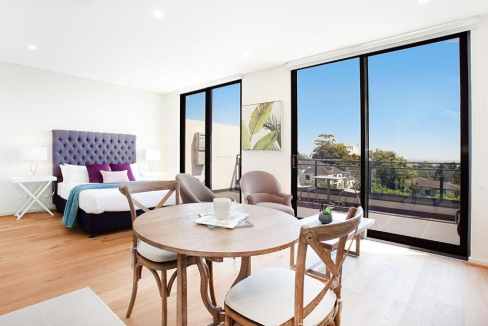 Bright living space with large windows overlooking the cityscape.
