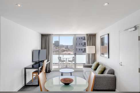 Apartment living room with city view, modern furniture, and natural light in Wollongong.