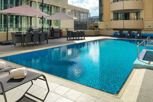 Rooftop pool at Canberra Braddon Aparthotel with sun loungers and outdoor seating.