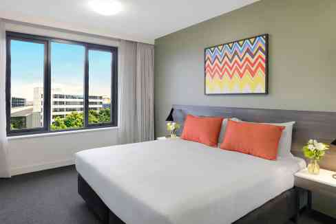 Comfortable hotel room at Sydney Mascot Airport Aparthotel with city views and contemporary decor.