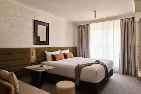 Modern hotel room at Sydney Town Hall Aparthotel with stylish decor and natural light.