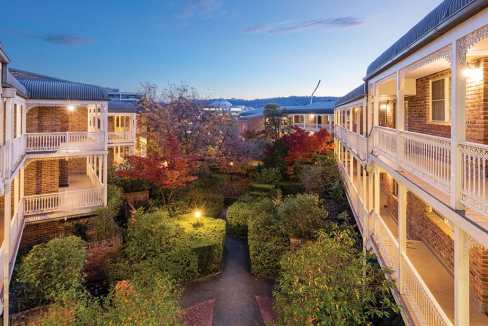 Exterior view of Canberra Kingston Aparthotel with lush garden and balcony views.