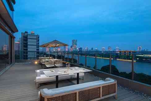 Rooftop lounge at Ningbo Riverside Aparthotel with city skyline and river view. Perfect for relaxing.