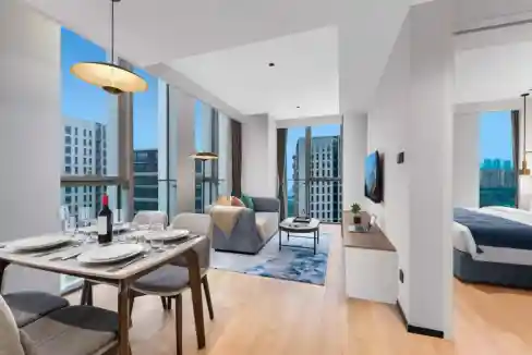Spacious living area at Chengdu Guanghua Aparthotel with large windows and cityscape views.