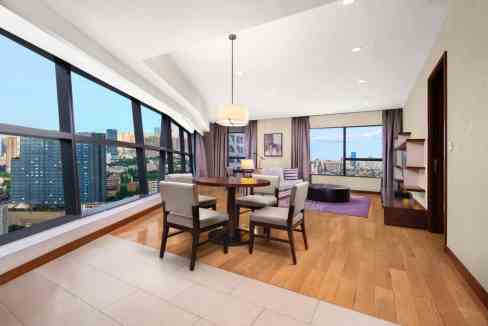 Spacious living area in Chengdu Sichuan Gymnasium Aparthotel featuring large windows and contemporar.