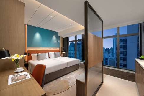 Spacious hotel room in North Point, Hong Kong, featuring modern furnishings and panoramic city views.