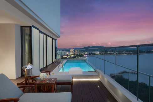 Rooftop pool at Sanya Dadonghai Bay Aparthotel with ocean views during sunset.