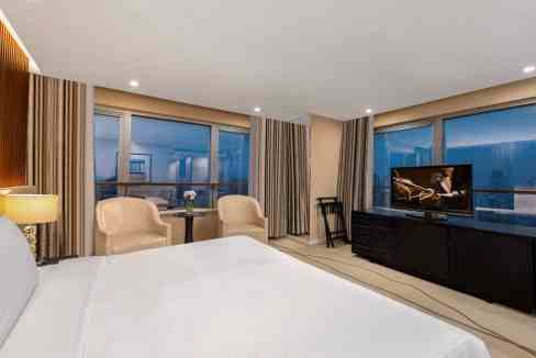 Modern hotel room with city views and comfortable seating.
