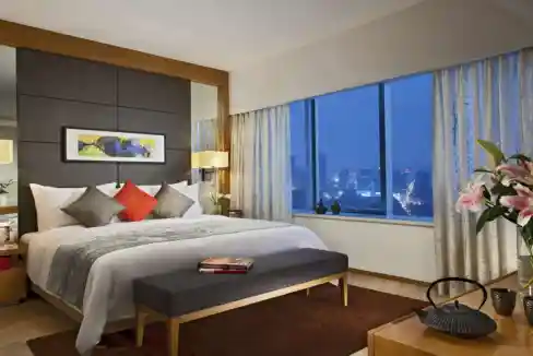 Spacious hotel room at Chengdu Nanhe River Aparthotel with cityscape views and contemporary furnishi.