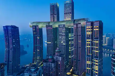 Modern high-rise buildings at Chaotianmen Wharf in Chongqing, illuminated at dusk.
