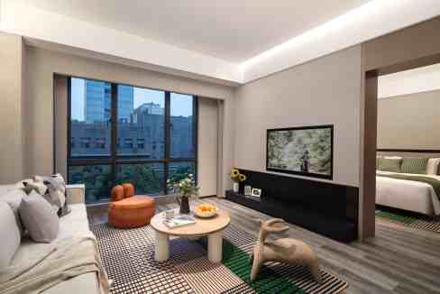 Elegant hotel living room with large window overlooking Chongqing skyline.