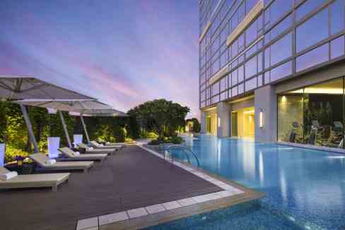 Modern outdoor pool at Macau Harbour Aparthotel with city views.