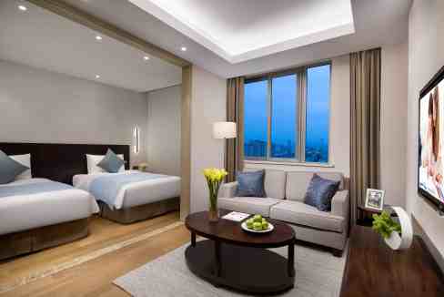 Modern living room at Suzhou Emerald City Aparthotel with stylish decor and city views.