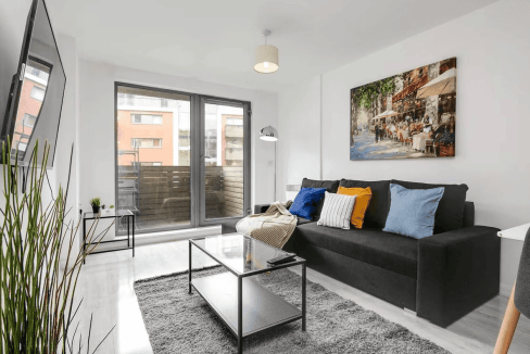 Bright living room in Birmingham Peace Gardens Apartments with large windows and contemporary furnis.