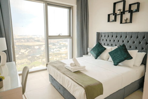 Spacious bedroom in Dubai Zaa'beel Second Apartments featuring a large window and cityscape view.