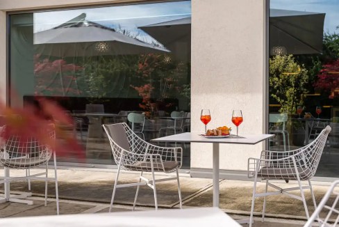 Outdoor dining setup at Lancenigo Aparthotel with modern chairs and table.