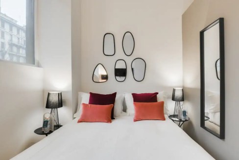 Cozy bedroom featuring contemporary decor, mirrors, and soft lighting at Via Orti Apartments. Perfec.