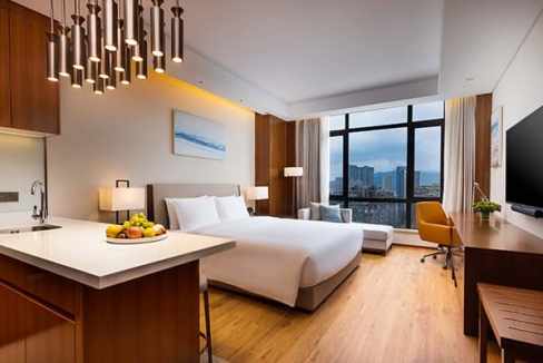 Aparthotel room at Hangzhou Tonglu with stylish furnishings, large window, and scenic cityscape.