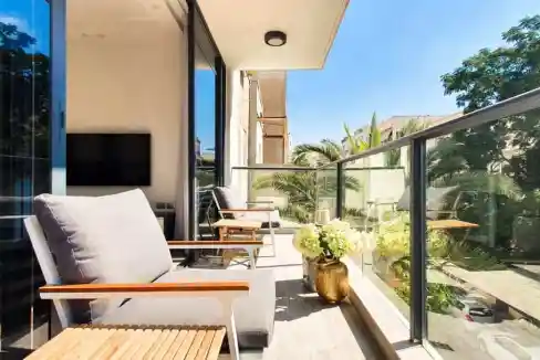 Balcony view of Ruppin Street Apartments with outdoor seating and lush greenery.