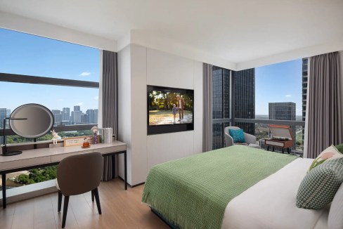 Modern hotel room with large windows overlooking Wuxi cityscape and wetland views.