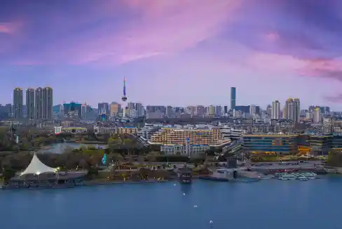 Aerial view of Xuzhou Yunlong Lake with city skyline and high-rise buildings at sunset.