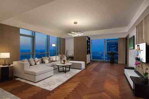 Spacious living room with large windows showcasing cityscape views in Xinwu District Aparthotel.