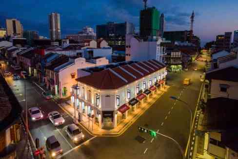 Night view of Penang Hutton Aparthotel with city skyline in the background.